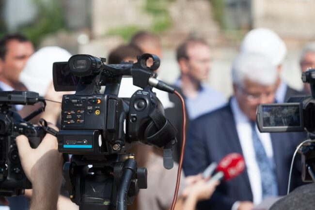 conversation article photo Cameras pointing towards group of people